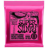 The image shows a bright pink Ernie Ball Super Slinky electric guitar strings package. It is a resealable zip-top bag featuring the black eagle logo. The strings are light gauge (9-42), nickel wound custom gauge, model 2223, made in the USA. Known for easy playability and balanced tone, these strings are popular among rock, pop, and blues guitarists.