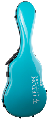 The image shows a modern hard shell guitar case from Teton Guitars in a glossy turquoise/teal finish. It features the distinctive guitar shape with "TETON GUITARS" and "BOZEMAN" in white lettering on the front. Made of molded fiberglass or similar material, it has black latches and a carrying handle. The bright color makes it stand out, offering strong protection and a sleek, professional look.