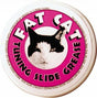 The image shows a container of Fat Cat Tuning Slide Grease, a lubricant for brass wind instruments. It has a pink label with a black and white cat face. This grease is applied to tuning slides—the U-shaped parts on brass instruments like trumpets and trombones—to keep them moving smoothly, aiding in pitch adjustment and preventing them from sticking.