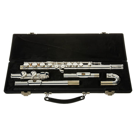 The image shows a silver-plated concert flute disassembled into head joint, body, and foot joint, neatly arranged in a black hard case with custom-fitted, dark fabric-lined compartments. The flute features polished keys with springs and pads. The case includes metal clasps and a handle. This woodwind instrument, commonly used in school bands and orchestras, appears to be a student or intermediate-level model.