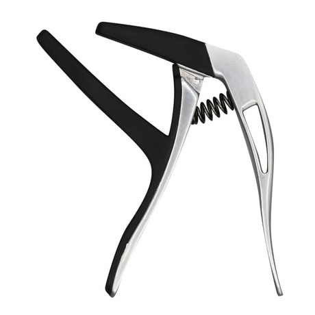 The image shows a spring-loaded trigger-style guitar capo with a silver metal frame and black rubber padding. It clamps onto the fretboard to raise the pitch of all strings, allowing guitarists to change keys, ease difficult chords, and alter tonal quality. The black padding protects the guitar while ensuring a secure grip, and the design enables quick one-handed positioning and removal.
