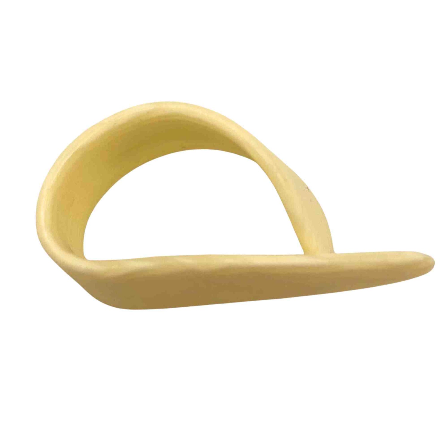 The image shows a cream-colored thumb pick made of smooth plastic, designed to wrap around the thumb with a flat picking surface extending outward. Used by fingerstyle guitarists and banjo players, it enhances volume and clarity for bass lines while allowing precise control. Common in folk, country, bluegrass, and classical styles, it aids in achieving bright, pronounced fingerpicking tones.