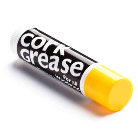 The image shows a tube of cork grease with a black label reading "Cork Grease" and "For all Woodwind." The yellowish grease is visible at the opening. Cork grease is used by woodwind players to lubricate cork joints, ensuring smooth assembly, preventing drying and cracking, creating airtight seals, and protecting cork for instruments like clarinets, saxophones, oboes, and bassoons.