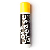 The image shows a tube of cork grease, an essential accessory for woodwind instruments. The black tube has white "Cork Grease" text and a bright yellow cap. Cork grease is applied to cork joints on clarinets, saxophones, oboes, and bassoons to ensure smooth assembly, protect cork from drying or damage, create airtight seals, and maintain instrument performance. It’s a vital maintenance item for woodwind players.