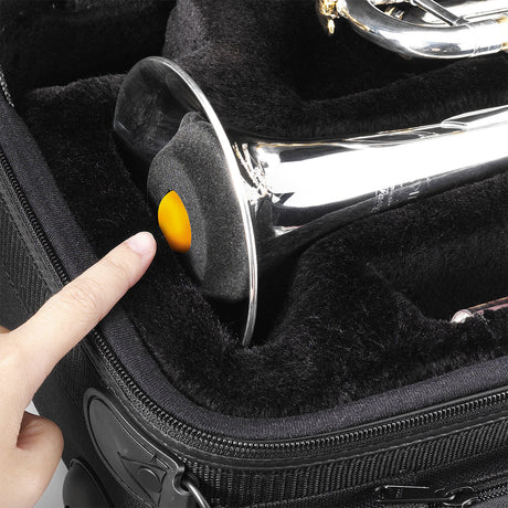 A folded up trumpet stand being stored in the bell of a trumpet inside a black case