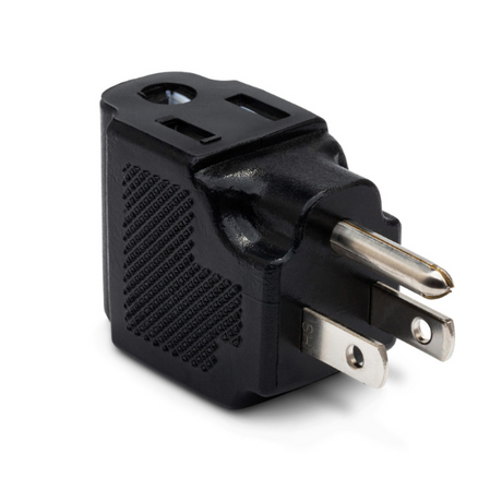 The image shows a compact black electrical adapter with multiple socket openings and prongs, designed to connect various plug types to different outlets. This universal adapter is useful for musicians who travel internationally with electronic gear like amplifiers, pedals, and keyboards, ensuring their equipment can be powered across countries with different electrical standards.