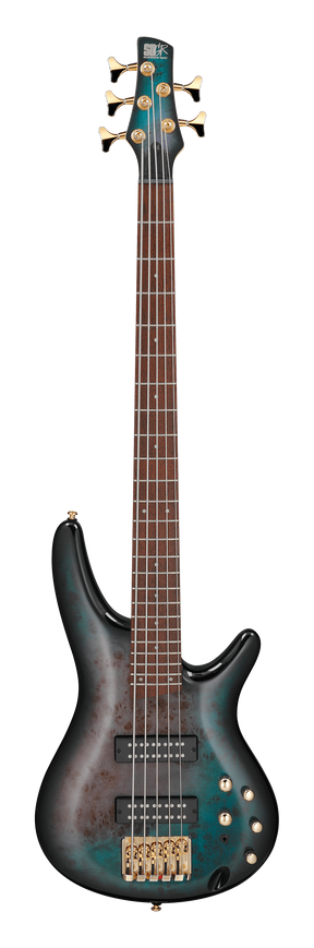 The image shows a beautiful 5-string electric bass guitar with a teal/turquoise burst finish and a classic double-cutaway body. It features two black humbucker pickups, gold hardware, multiple control knobs, and a rich brown fretboard with light markers. The gold tuning pegs match the five strings. A logo is faintly visible on the headstock. This high-end instrument combines premium craftsmanship with professional design for serious musicians.
