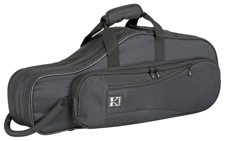 The image shows a charcoal gray soft-sided gig bag for a tenor saxophone or similar wind instrument. It has multiple zippered pockets, padded handles, an adjustable shoulder strap, and a white logo featuring a "K" or similar letter. The durable, reinforced case has an elongated curved shape matching the instrument, designed for lightweight, portable protection and accessory storage.