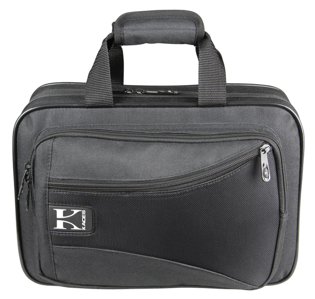 The image shows a durable gray soft-sided gig bag or musical instrument case with a padded handle, multiple zippered compartments, and reinforced edges. It features a "KACES" logo and a professional, utilitarian design. Sized for small keyboards, audio gear, wind instruments, or accessories, it offers lightweight, portable protection for musicians' equipment.