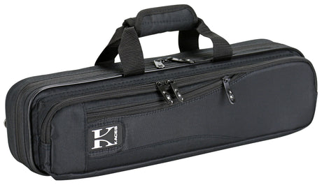 The image shows a black soft-sided flute case with a durable nylon or canvas exterior. It has dual padded carry handles, multiple zippered compartments for storage, and a brand logo patch (possibly "Kaces"). Designed for professional protection, the case is ideal for flute players to safely transport their instrument and accessories like cleaning cloths and sheet music.