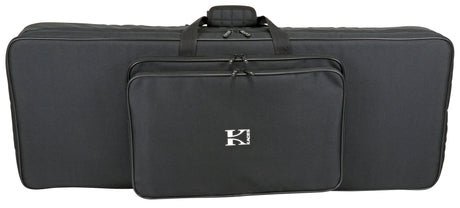 The image shows a black soft-sided keyboard gig bag with padded protection, multiple carrying handles, and several zippered compartments for an electronic keyboard or digital piano. It features a white "K" logo, likely from the Kaces brand, and includes storage pockets for accessories, making it lightweight and portable for musicians transporting their instruments and gear.