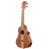 The image shows a beautiful wooden ukulele with natural grain, likely mahogany or koa. It is a concert or tenor size with four strings, a wooden fretboard with markers, and a headstock featuring four tuning pegs and a logo. It has a round sound hole, a cutaway design for access to higher frets, and an input jack, indicating it is an acoustic-electric model with a warm, polished finish.