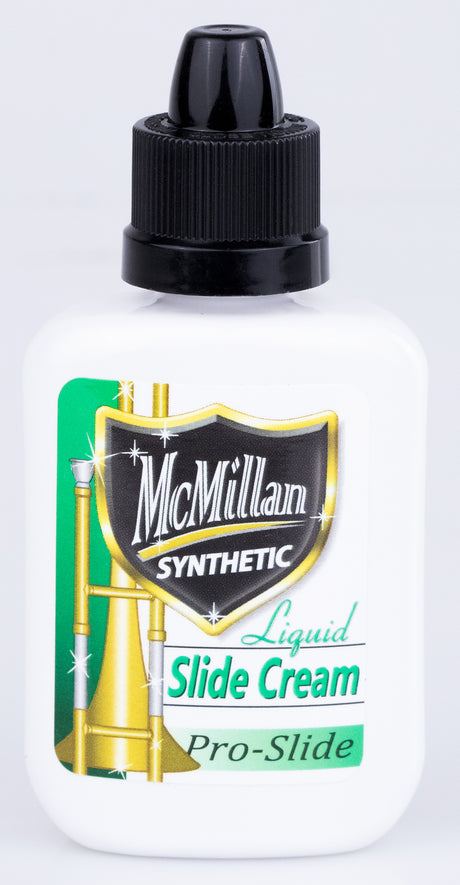The image shows a bottle of McMillan Synthetic Liquid Slide Cream Pro-Slide, a professional-grade slide lubricant for brass instruments, especially trombones. The small dropper bottle has a black cap, McMillan branding, a "SYNTHETIC" shield logo, and brass instrument graphics. This synthetic slide cream ensures smooth slide movement with precise application, making it essential for trombone maintenance.