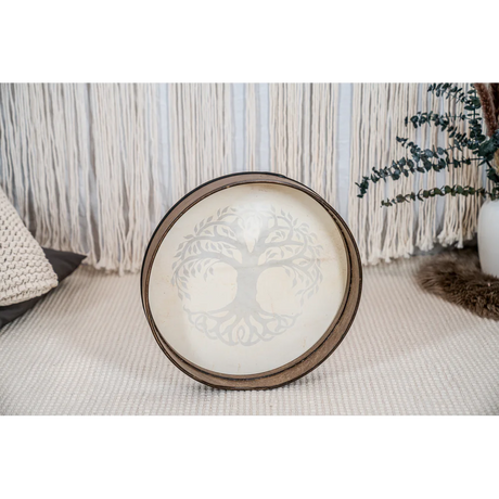 Decorative hand drum with tree of life design on a textured surface