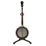The image shows a 5-string banjo with a circular body and white drumhead, a long reddish-brown wooden neck, and a black headstock with tuning pegs. It has metal hardware including a tailpiece and tension brackets around the rim. The instrument rests on a black tripod stand and features a strap attachment on the neck. Common in bluegrass and folk music, it combines string and percussion elements with roots in American and African musical traditions.