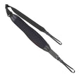 The image shows a black guitar strap with a wide padded shoulder section for comfort, adjustable length via metal buckles, and brown leather end tabs for secure attachment. Made from durable fabric webbing, it features metal hardware for connecting to the guitar. This practical strap helps distribute the guitar’s weight, reducing fatigue during extended playing, and is suitable for acoustic, electric, or bass guitars.