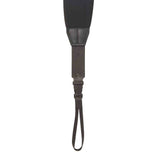 The image shows a black guitar strap with padded shoulder support, made of leather or synthetic leather with contrasting reinforced stitching. It features an adjustment mechanism in the middle and a thin cord at the bottom for securing to the guitar. Designed for comfort and durability, this premium strap helps distribute the instrument's weight for easier playing while standing.