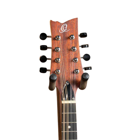 The image shows the headstock of an 8-string acoustic guitar with a curved reddish-brown wood design. It has eight black tuning pegs in a 4+4 layout, chrome metal tuners, and a white/pearl "Q" inlay or logo. Visible are guitar strings and part of the dark wood fretboard with position markers. The unique design and details suggest a high-quality, possibly custom or boutique instrument.
