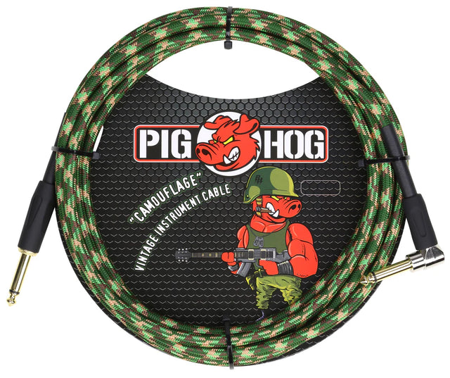 The image shows a Pig Hog "Camouflage" vintage guitar cable with a green, brown, and tan woven fabric jacket. It features the Pig Hog red pig logo and a military-themed cartoon pig in combat gear holding a guitar. The cable has professional 1/4" gold-plated connectors, with one straight and one right-angle plug, designed for electric guitars and basses.