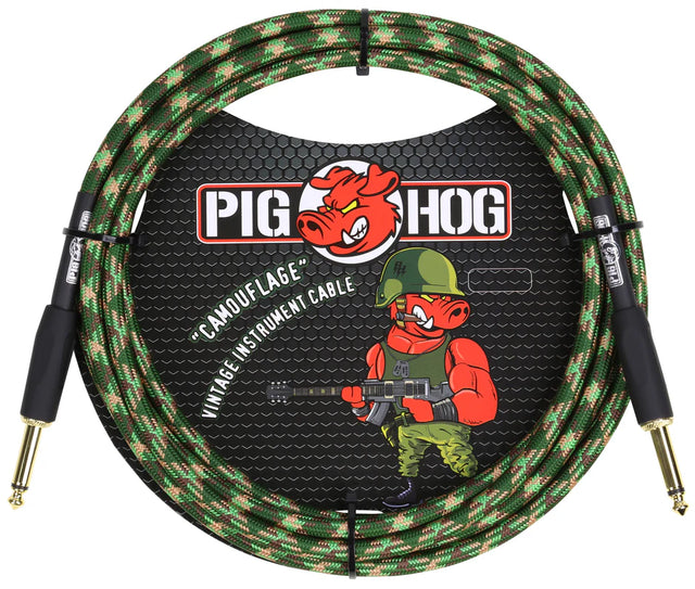 The image shows a Pig Hog brand instrument cable with a green camouflage woven jacket and gold-plated 1/4" connectors. It features the red pig mascot in military gear holding a guitar, emphasizing the military-themed vintage design. The cable is packaged in retail packaging with a black honeycomb background. This durable cable is designed for electric guitars, basses, and other instruments, offering reliable audio and a distinctive style.