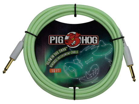 The image shows a coiled Pig Hog "Glow in the Dark" vintage 10-foot instrument cable with light green color and gold-plated 1/4" connectors with white housings, secured by black ties. The packaging features the Pig Hog logo with a red boar head and artwork of a glowing guitar on a dark background. This cable is used to connect electric guitars and other instruments to amplifiers or pedals.