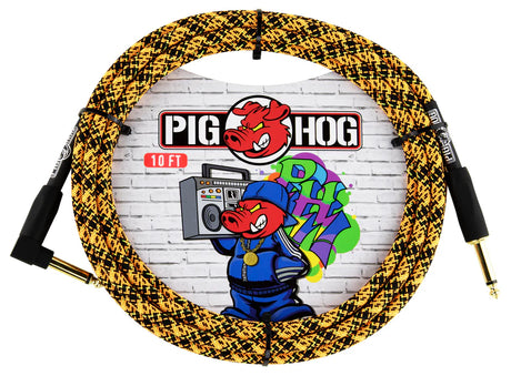 The image shows a Pig Hog guitar cable with a yellow and black braided exterior, gold-plated 1/4" connectors, and black housings. The packaging features the Pig Hog logo with a red pig mascot dressed in a blue tracksuit holding a boom box, set against colorful graffiti-style lettering and a brick wall background. The 10 FT cable is known for durability and quality, favored by musicians for reliable instrument connections.
