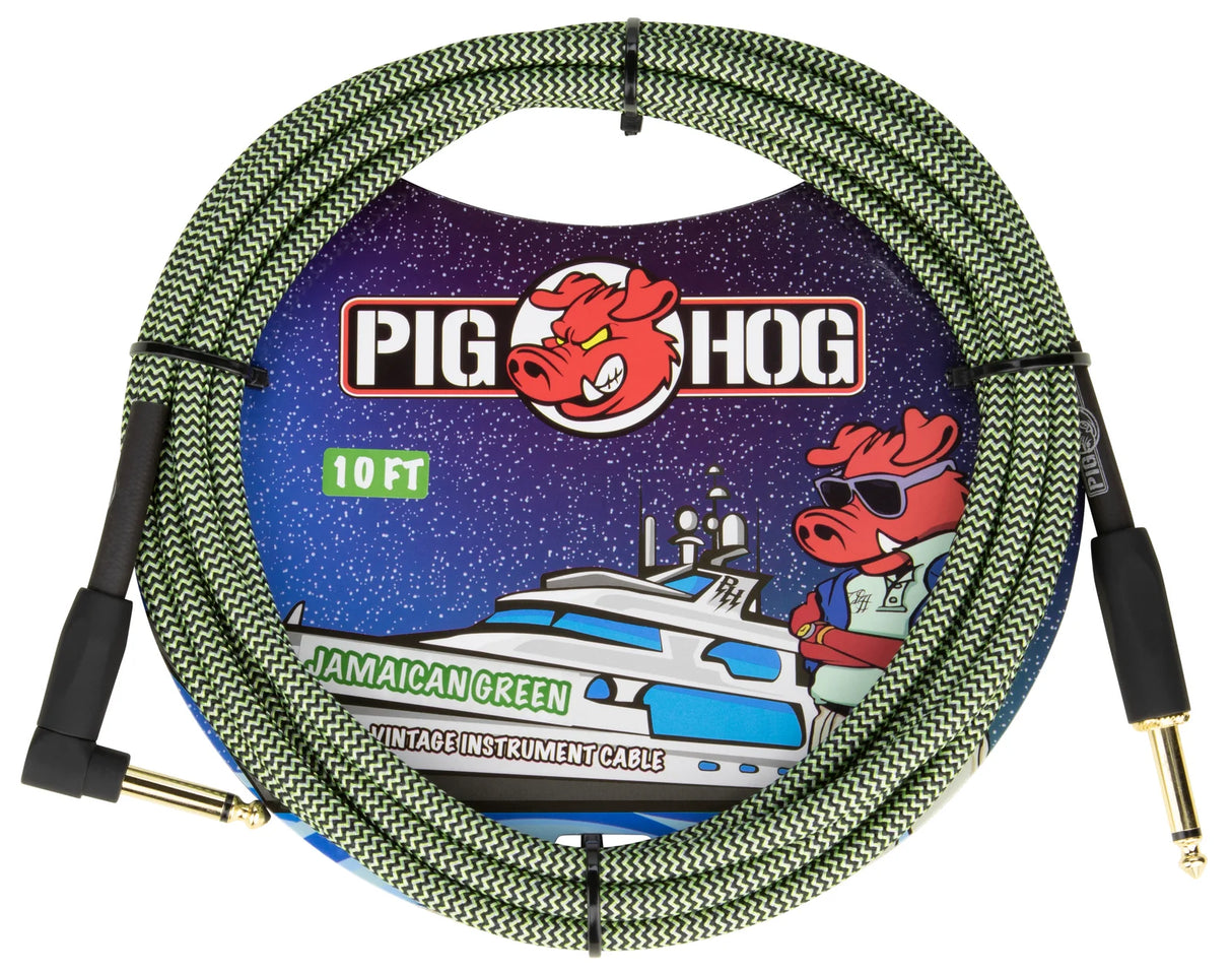 The image shows a Pig Hog 10-foot "Jamaican Green" vintage instrument cable with a green and black braided zigzag exterior and gold-plated 1/4" connectors—one straight and one right-angle. The packaging features the Pig Hog red pig mascot wearing sunglasses and a yacht illustration. This durable cable is designed for reliable signal transmission between guitars or instruments and amps or pedals.