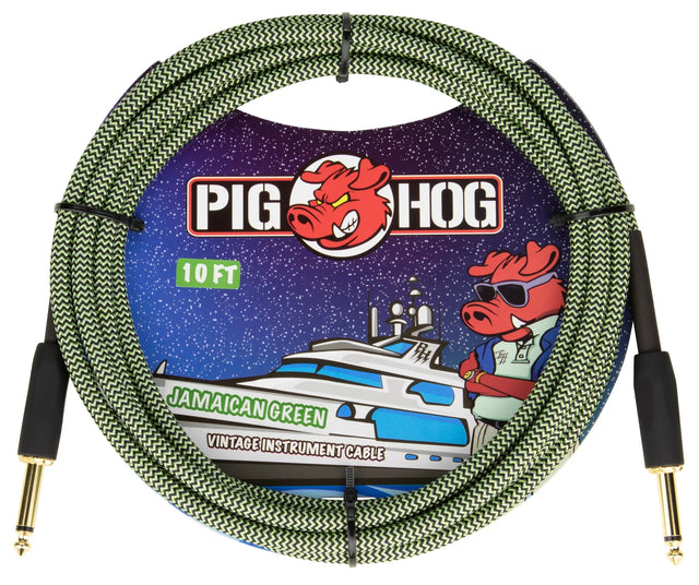 The image shows a 10-foot Pig Hog "Jamaican Green" vintage instrument cable with a green and black woven design, gold-plated 1/4" connectors, and the red pig mascot logo. The packaging features colorful space-themed artwork with the mascot on a yacht. This durable, professional-grade cable is used for connecting guitars, basses, keyboards, and other instruments to amplifiers or audio equipment.