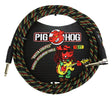 The image shows a Pig Hog "Rasta Stripes" 10-foot vintage instrument cable with a woven exterior in red, yellow, and green stripes on black. It has 1/4" connectors on both ends for electric instruments. The packaging displays the Pig Hog logo with a red pig mascot and a cartoon pig playing guitar in Rastafarian attire. The braided jacket offers durability, tangle resistance, and a distinctive look for professional musicians.