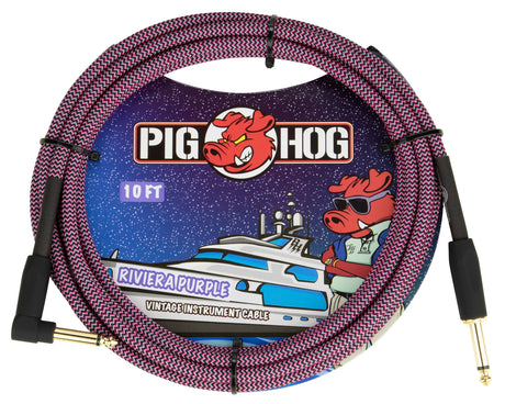 The image shows a Pig Hog 10-foot "Riviera Purple" vintage instrument cable with 1/4" gold-plated connectors on both ends. The cable has a purple and black woven zigzag fabric jacket for durability and style. The packaging features the Pig Hog logo with a red pig mascot wearing sunglasses against a starry background with a boat. This cable is used to connect guitars and other instruments to amps or pedals.