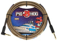The image shows a Pig Hog "Tuscan Brown" vintage-style instrument cable. It is a 10-foot braided brown/tan cable with gold-plated 1/4" jack connectors on both ends, designed for guitars, basses, or pedals. The packaging features Pig Hog’s cartoon pig mascot and space-themed art, highlighting its retro look and reliable signal transmission favored by musicians.