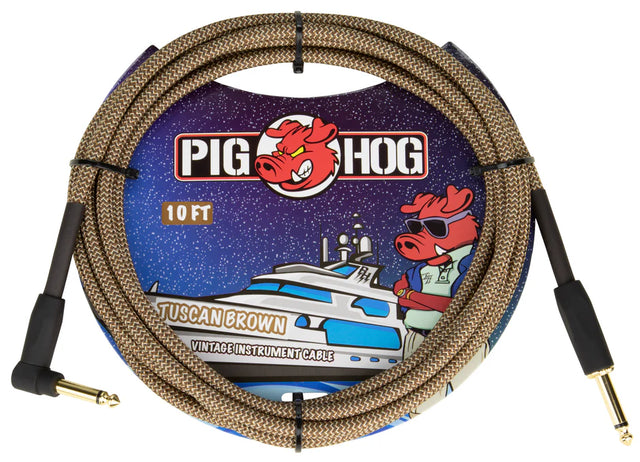The image shows a Pig Hog "Tuscan Brown" vintage-style instrument cable. It is a 10-foot braided brown/tan cable with gold-plated 1/4" jack connectors on both ends, designed for guitars, basses, or pedals. The packaging features Pig Hog’s cartoon pig mascot and space-themed art, highlighting its retro look and reliable signal transmission favored by musicians.