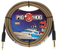 The image shows a Pig Hog Tuscan Brown 10-foot instrument cable with gold-plated 1/4" connectors on both ends. It features a woven brown/tan braided fabric jacket, vintage-style design, and Pig Hog’s red pig mascot logo. The professional packaging has colorful yacht-themed graphics. This durable, high-quality cable is designed for guitars, basses, and other instruments, offering reliable signal transfer and protection for studio or live use.