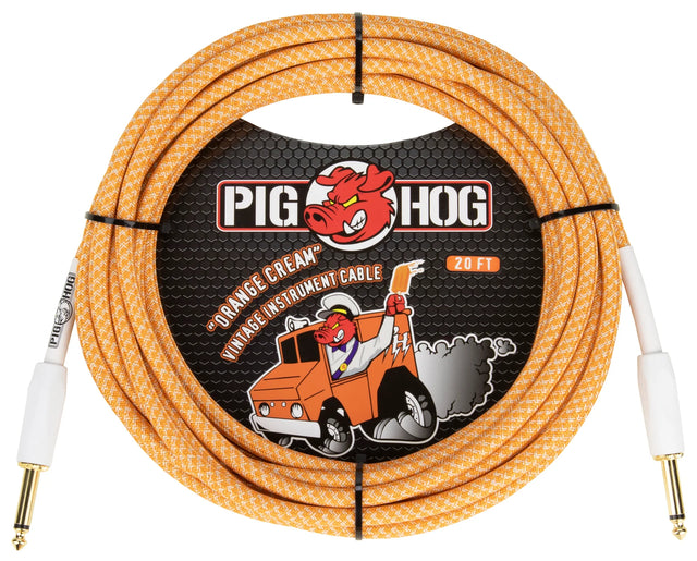 The image shows a Pig Hog "Orange Cream" vintage 20-foot instrument cable with 1/4" gold-plated connectors and white strain relief boots. The cable has an orange and white braided exterior with a retro pattern. The packaging features the Pig Hog logo, a red pig mascot, and cartoon art of the pig driving an orange truck, reflecting the brand’s vintage, road-worn style. This durable cable is designed for guitars, basses, and other electronic instruments.