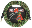 The image shows a Pig Hog vintage instrument cable with a green and tan camouflage woven jacket. It features gold-plated 1/4" connectors—one straight and one right-angle—for versatile use. The cable is labeled for musical instruments and displays the Pig Hog logo with a red pig mascot in military gear. Its durable woven exterior offers protection and tangle resistance, combining reliability with a unique vintage military style.