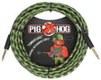 The image shows a Pig Hog "Camouflage" vintage-style instrument cable about 20 feet long. It features a woven fabric exterior in green, brown, and tan camo, gold-plated 1/4" connectors, and professional-grade construction. The cable displays the Pig Hog branding with a cartoon pig mascot in military gear, combining a rugged tactical look with high-quality performance for connecting electric instruments to audio gear.