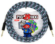 The image shows a Pig Hog 20-foot instrument cable with a colorful woven fabric sleeve in black, white, pink, and teal. It has gold-plated 1/4" connectors on both ends. The packaging features the Pig Hog logo with a red pig mascot and graffiti-style artwork on a brick wall, giving an urban, street art look. This premium cable is designed for reliable performance and distinctive style.
