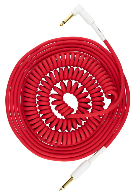 The image shows a bright red coiled guitar cable with gold-plated 1/4" TS connectors and white housings. It features one right-angle and one straight plug, commonly used to connect guitars or basses to amplifiers or pedals. The coiled design prevents tangling, enhances flexibility, and reduces stage clutter, making it a reliable and iconic accessory for live and studio use.