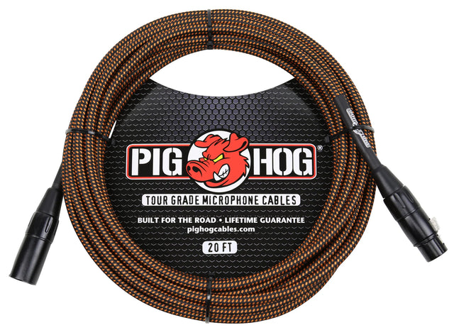 The image shows a Pig Hog tour-grade 20-foot microphone cable with black and orange braided sleeve. It features XLR male to female connectors and a label displaying the Pig Hog red pig logo, "Built for the Road," and "Lifetime Guarantee." Designed for durability, this professional cable is ideal for live sound and touring musicians.