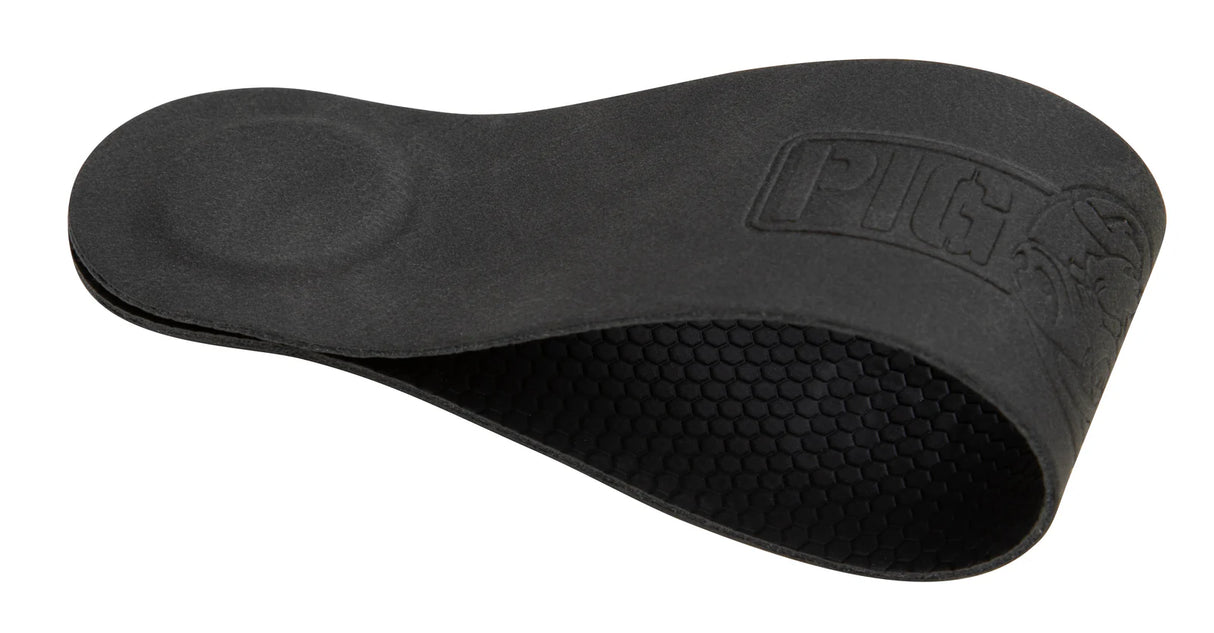 The image shows a black guitar shoulder rest with an ergonomic curved shape and padded surface for comfort. It features a textured honeycomb grip on the bottom to prevent slipping and has "PURE" branding embossed. This accessory helps classical and acoustic guitarists improve posture, reduce strain, and stabilize the guitar during extended playing sessions.