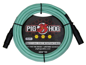 The image shows a 15-foot Pig Hog Professional Series XLR microphone cable with seafoam green/turquoise jacket and black metal connectors. It features male to female connectors, the red pig logo, yellow "HEX" badges, and "Built for the Road • Lifetime Guarantee" branding. Designed for professional audio use, this durable cable is ideal for microphones and audio equipment in live and studio settings.