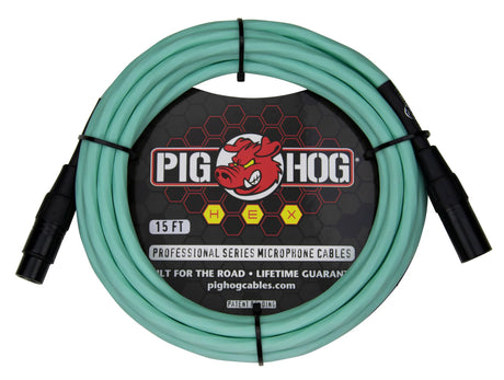 The image shows a 15-foot Pig Hog Professional Series XLR microphone cable with seafoam green/turquoise jacket and black metal connectors. It features male to female connectors, the red pig logo, yellow "HEX" badges, and "Built for the Road • Lifetime Guarantee" branding. Designed for professional audio use, this durable cable is ideal for microphones and audio equipment in live and studio settings.