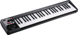The image shows a Roland A-49 MIDI keyboard controller with 49 black and white piano keys. It has a sleek black casing and control buttons, including a modulation wheel, on the left side. This compact, portable device is used by musicians and producers to input notes and control music software. Roland is known for high-quality electronic instruments suitable for both studio and live performances.