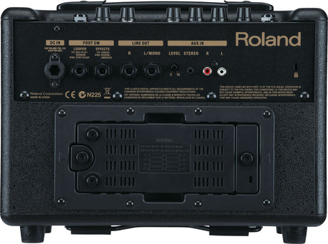 The image shows the back panel of a Roland guitar amplifier featuring DC power input, foot switch jack, left and right line outputs, and auxiliary input with level controls. It has multiple control knobs, a battery compartment with ventilation, and Roland branding. The compact, portable design supports battery operation, built-in effects, and loop control, making it suitable for practice, busking, or small performances.