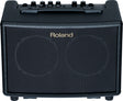 The image shows a compact Roland acoustic guitar amplifier with a black textured front grille and the Roland logo. It has six control knobs on the top panel, a sturdy black carrying handle, and "ACOUSTIC GUITAR AMP" text visible. Designed for acoustic guitar players, this portable practice amp offers clean sound and built-in effects for small venues, practice, or recording.