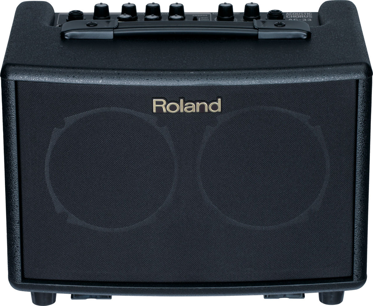 The image shows a compact Roland acoustic guitar amplifier with a black textured front grille and the Roland logo. It has six control knobs on the top panel, a sturdy black carrying handle, and "ACOUSTIC GUITAR AMP" text visible. Designed for acoustic guitar players, this portable practice amp offers clean sound and built-in effects for small venues, practice, or recording.