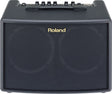 The image shows a compact black Roland guitar amplifier with gold branding on the front grille. It has six black control knobs and additional switches on the top panel, along with a carrying handle. Designed for acoustic guitars, the amp features a clean, professional look with black tolex covering. Ideal for practice and small performances, it combines portability with quality sound, suitable for beginners and professionals.