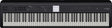 The image shows a Roland digital piano with classic black and white keys in a standard layout. Above the keys is a control panel featuring buttons, sliders, and a small central display screen. The Roland logo is visible in the top right corner. This digital piano replicates an acoustic piano’s feel and sound while offering additional features like multiple instrument voices, recording options, and sound effects.