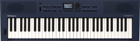 The image shows a Roland GO:KEYS 3 electronic keyboard with a 61-key piano-style layout in a dark blue body. It features built-in speakers on both sides, a small central LCD screen, multiple control knobs and buttons for sound and rhythm settings, and volume controls. The Roland logo is on the left, with the GO:KEYS 3 model name on the right. This portable keyboard is designed for beginners and casual players.