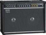The image shows a Roland Jazz Chorus-120 guitar amplifier with a black tolex exterior, metal corner protectors, and a large grille covering dual speakers. The control panel features two channels, multiple tone and volume knobs, and built-in effects like chorus and reverb. The amp is known for its clean tone, 120-watt power, and durable, professional-grade construction favored by jazz and clean guitar players.
